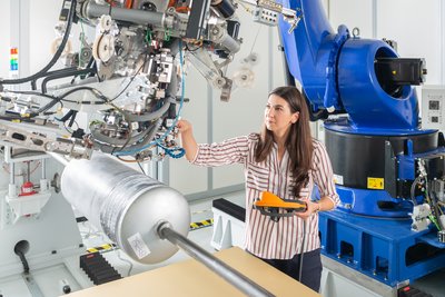 Frau bedient Roboter in einem Labor auf dem Gelände BTU Cottbus-Senftenberg
